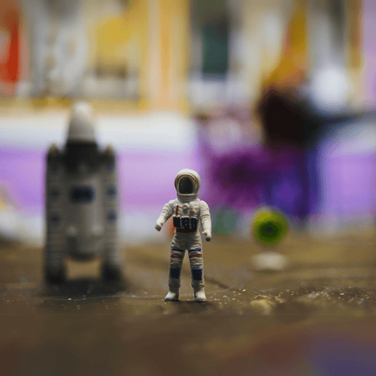 Astronaut toy sitting on a colorful play mat in a well-designed play space with shelves of toys in the background